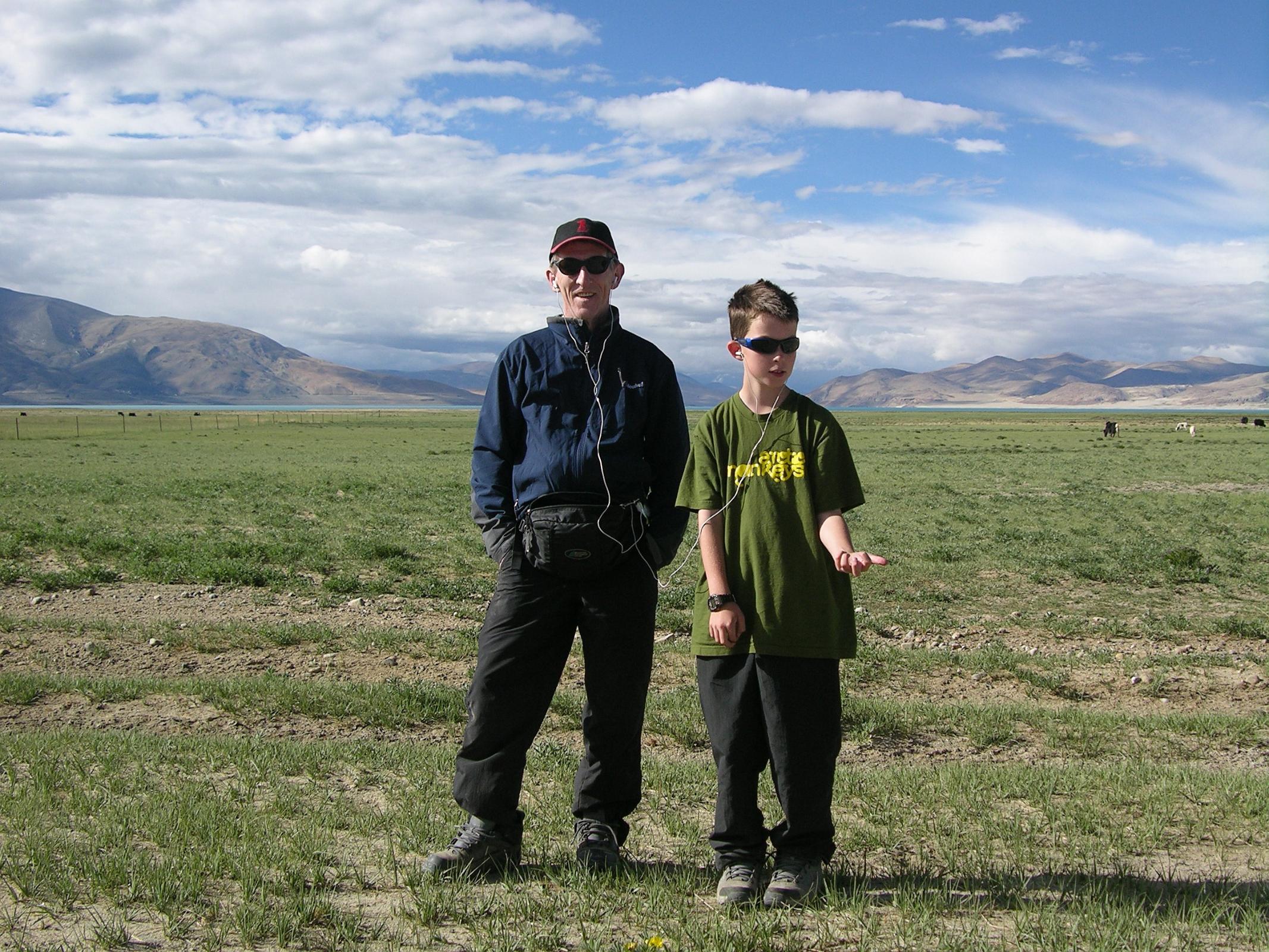 Tibet Kailash 11 Back 07 Listening to Ipod With Peiku Tso behind - Waiting For Landcruiser To Be Fixed Pete and I rocked to his Ipod as Sadim and crew fixed the Land cruiser near Peiko Tso. Cool!